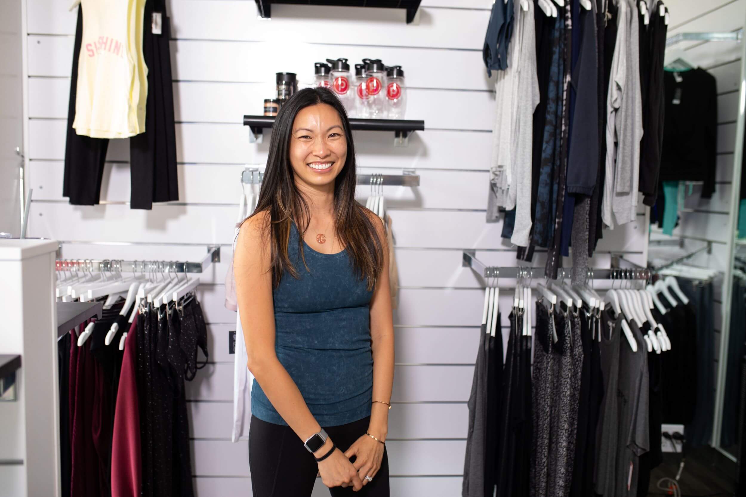 Person smiling next to Pure Barre merchandise