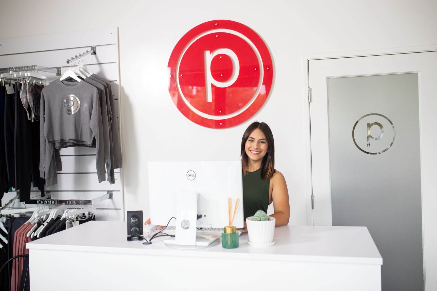 Person smiling behind front desk at Pure Barre